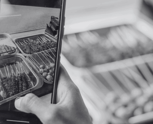 Person holding a phone, recording a reel of food.