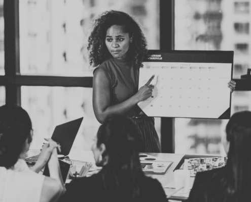 Woman holding calendar in front of meeting