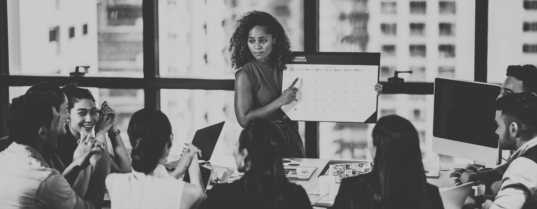Woman holding calendar in front of meeting